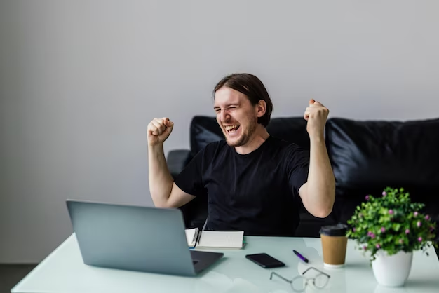 A man in a black T-shirt laughs with his hands up